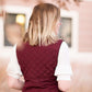 Woman wearing a cold weather, quilted puffer vest. This vest comes in mauve, black, navy and wine. It features pockets and a front zip.