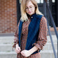 Woman wearing a cold weather, quilted puffer vest. This vest comes in mauve, black, navy and wine. It features pockets and a front zip.