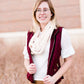 Woman wearing a cold weather, quilted puffer vest. This vest comes in mauve, black, navy and wine. It features pockets and a front zip.