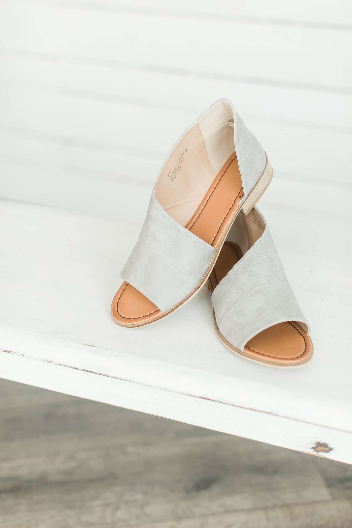 Grey or cognac sandal with enclosed heel, open toe and large leather wrap around strap.