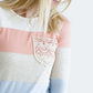 Woman wearing a modest peach, ivory, blue and navy 3/4 top with a lace pocket