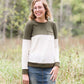 oatmeal colored sweater with olive stripe block top and front pocket.