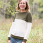 oatmeal colored sweater with olive stripe block top and front pocket.
