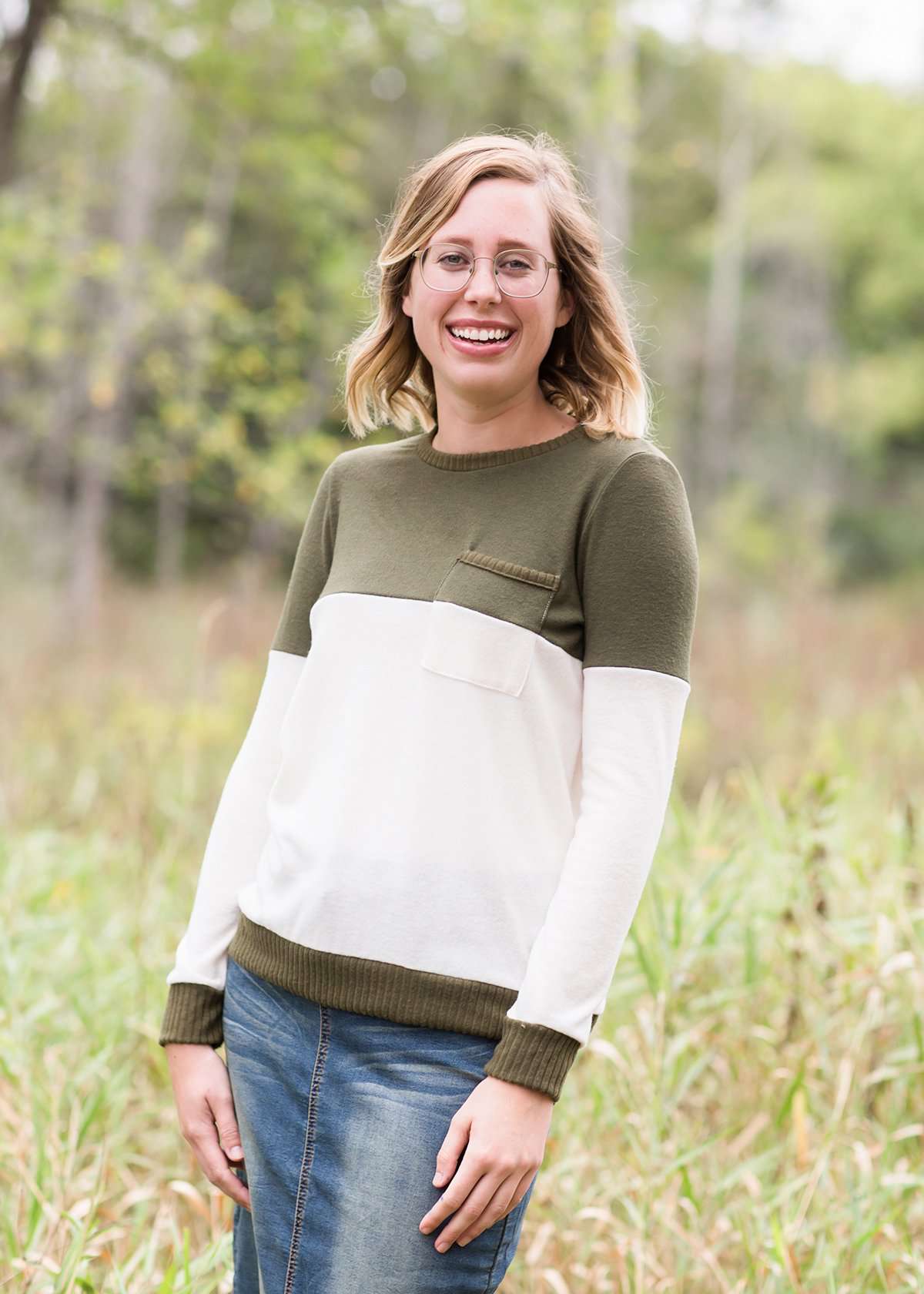 oatmeal colored sweater with olive stripe block top and front pocket.