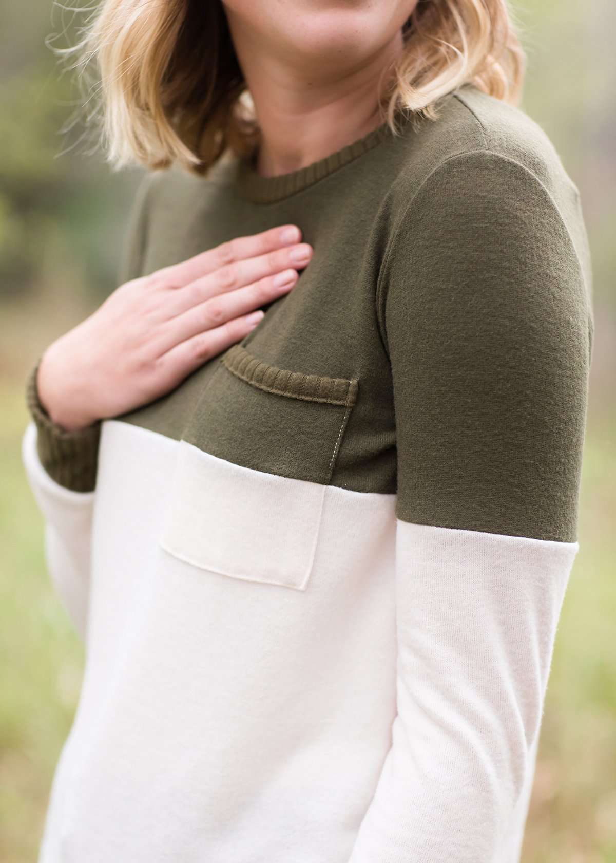 oatmeal colored sweater with olive stripe block top and front pocket.