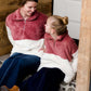 Young girl wearing a mauve and cream plush, sherpa style quarter zip sweater. This sweater has pockets and is paired with a long denim skirt. It is also a mommy and me style!