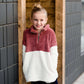Young girl wearing a mauve and cream plush, sherpa style quarter zip sweater. This sweater has pockets and is paired with a long denim skirt. It is also a mommy and me style!