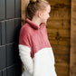 Young girl wearing a mauve and cream plush, sherpa style quarter zip sweater. This sweater has pockets and is paired with a long denim skirt. It is also a mommy and me style!
