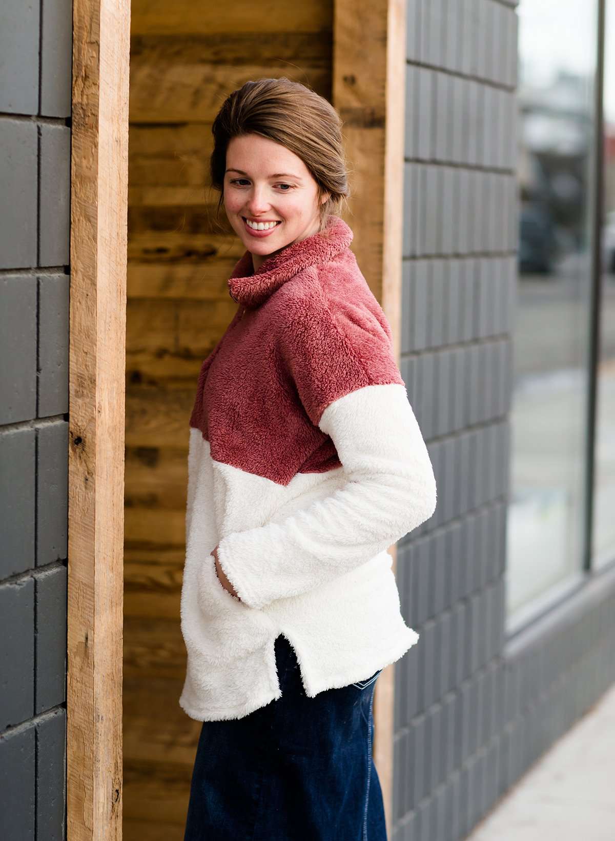 Modest Woman wearing a mauve and cream color block sherpa style sweater. This sweater has pockets and is also a mommy and me style.