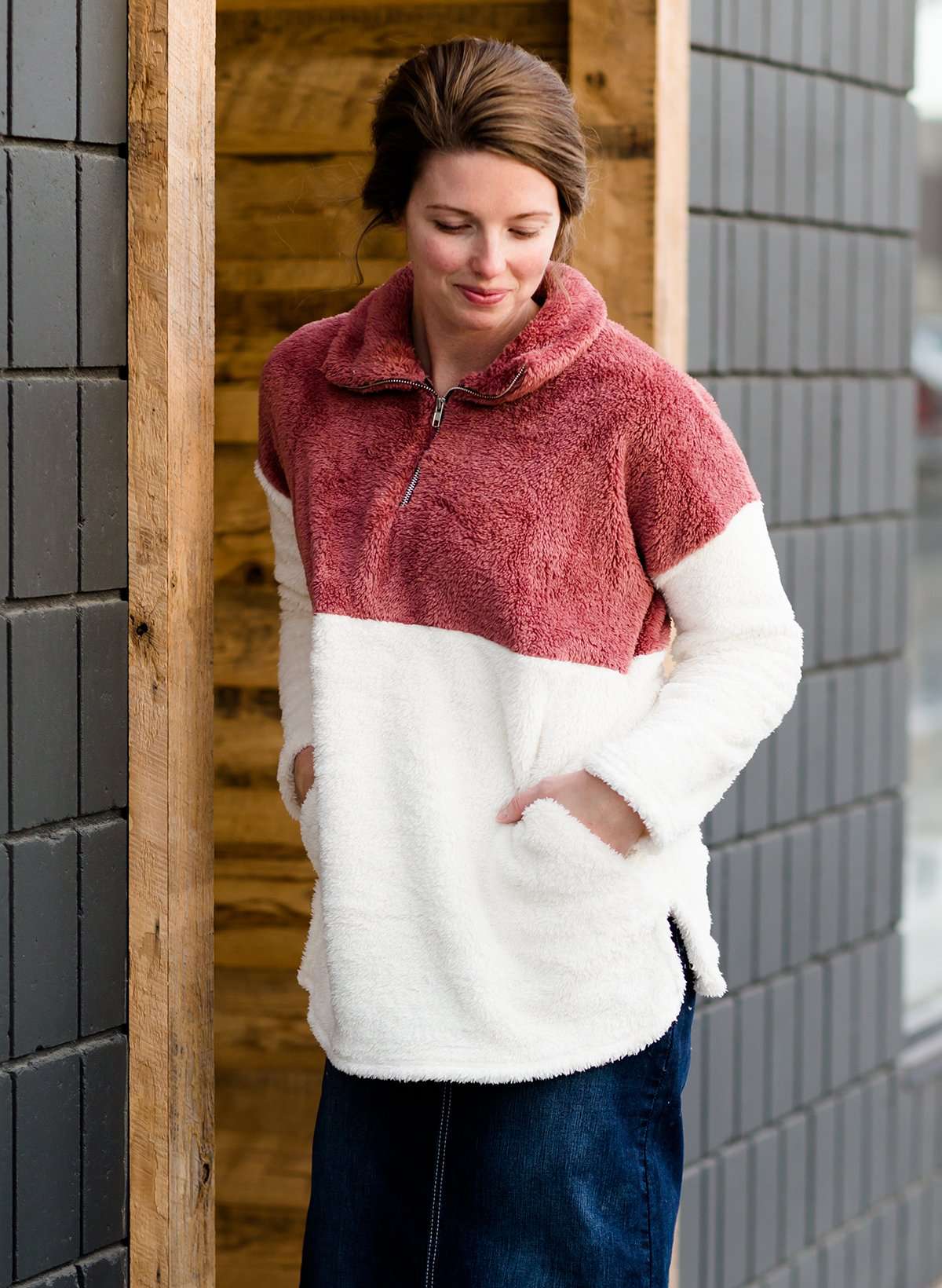 Modest Woman wearing a mauve and cream color block sherpa style sweater. This sweater has pockets and is also a mommy and me style.