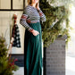 Woman wearing a striped top and solid hunter green bottom maxi dress.