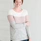 woman wearing a modest, soft sweater that is color blocked with white, mauve and gray.