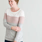 woman wearing a modest, soft sweater that is color blocked with white, mauve and gray.