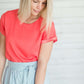 modest coral blouse with a different shade coral at the end hem of the sleeve.