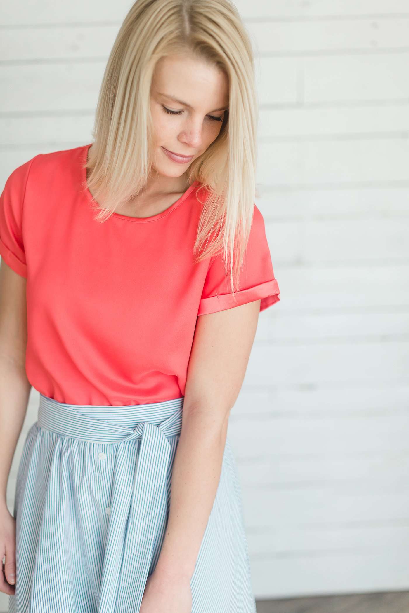 modest coral blouse with a different shade coral at the end hem of the sleeve.