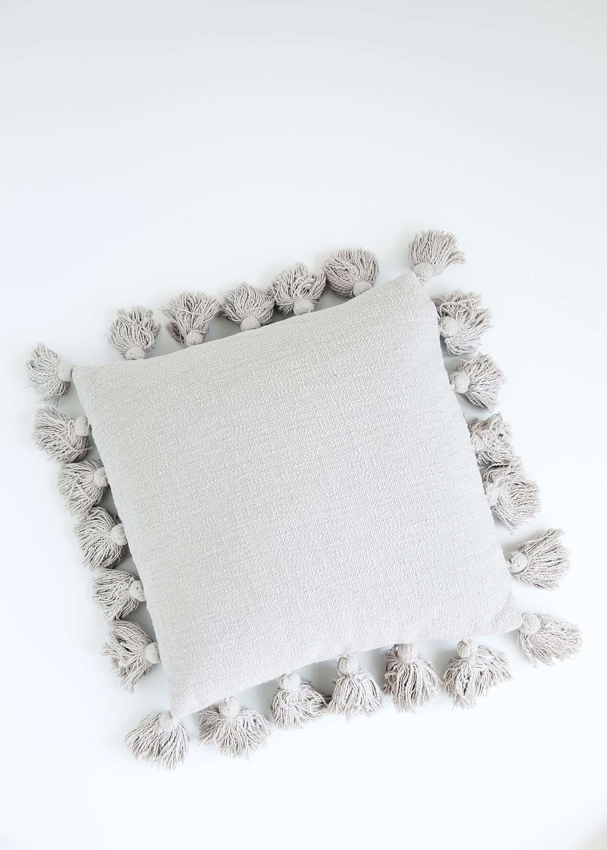 gray textured cotton throw pillow with tassels