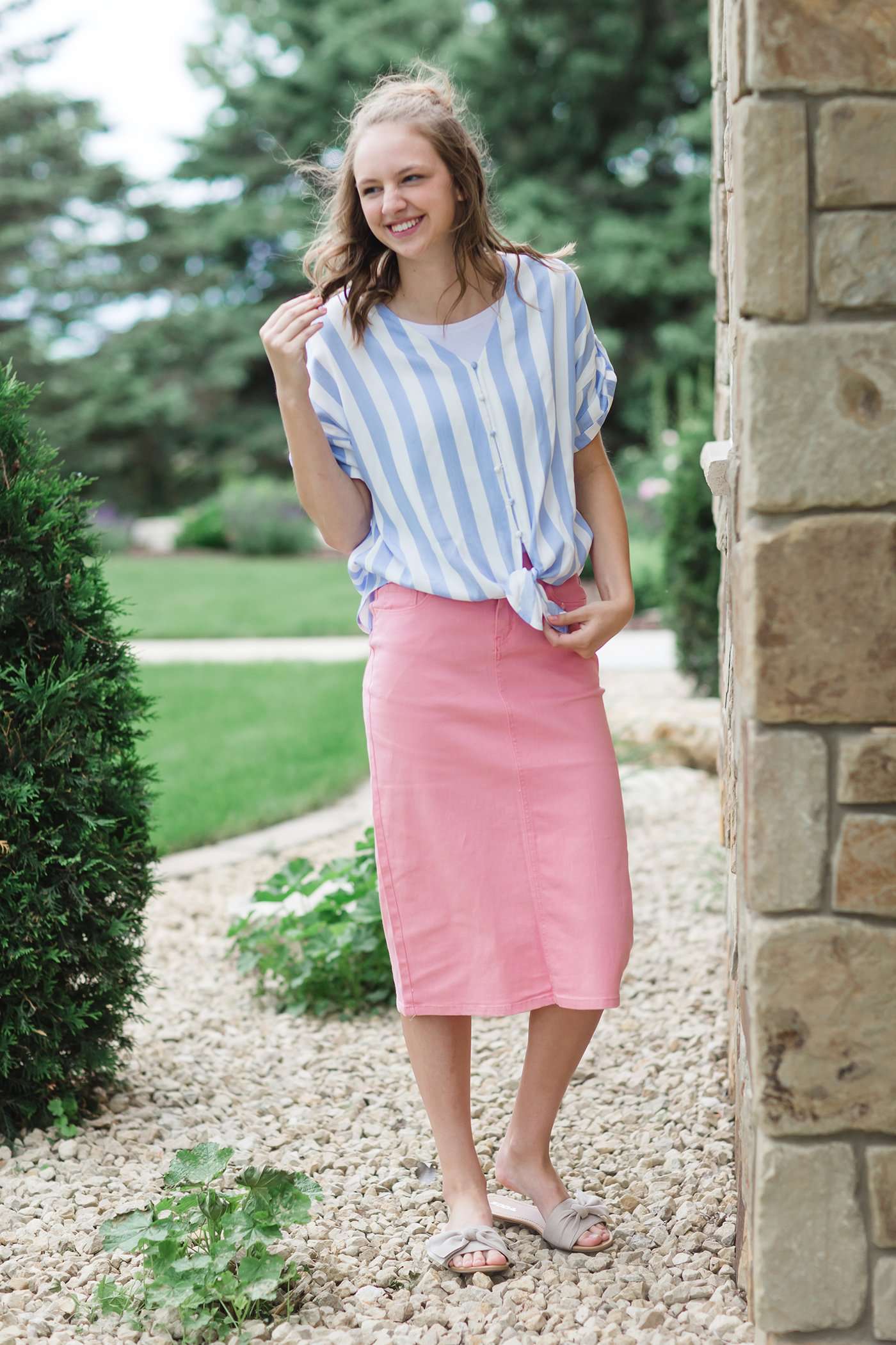 Blue and white vertical stripe top with short roll up sleeves and a tie front. Buttons up the front to a v-neck.