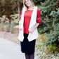 Young woman in a modest black midi skirt wearing a cream colored, soft drape style vest.