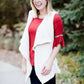 Young woman in a modest black midi skirt wearing a cream colored, soft drape style vest.