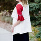 Young woman in a modest black midi skirt wearing a cream colored, soft drape style vest.
