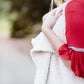 Young woman in a modest black midi skirt wearing a cream colored, soft drape style vest.