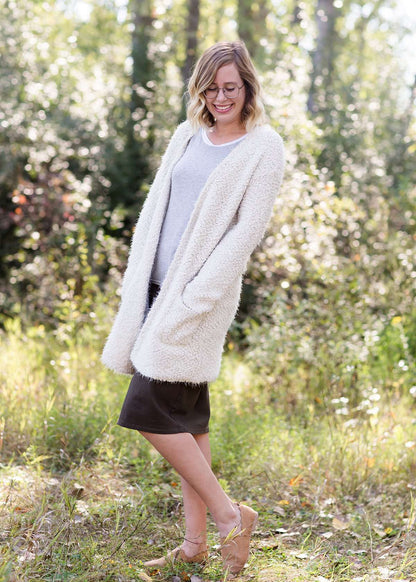 Women's cozy long vanilla cardigan with clasp close front and two side pockets.