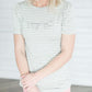 Grey and white striped crew neck tee shirt with a ruffle just above the chest.