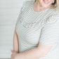 Grey and white striped crew neck tee shirt with a ruffle just above the chest.