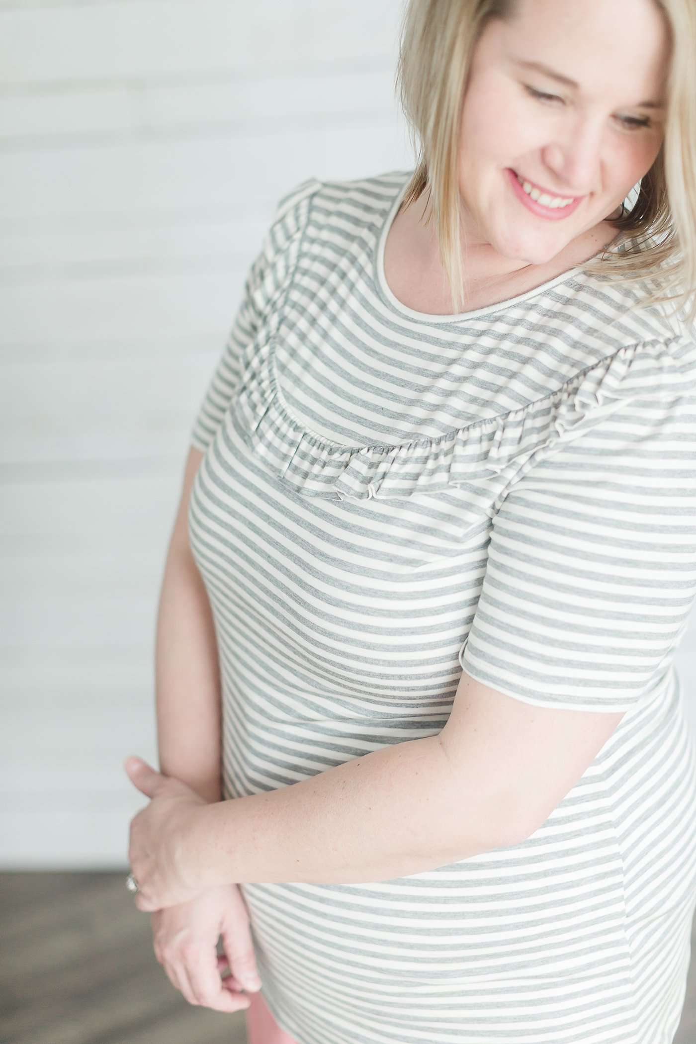 Grey and white striped crew neck tee shirt with a ruffle just above the chest.