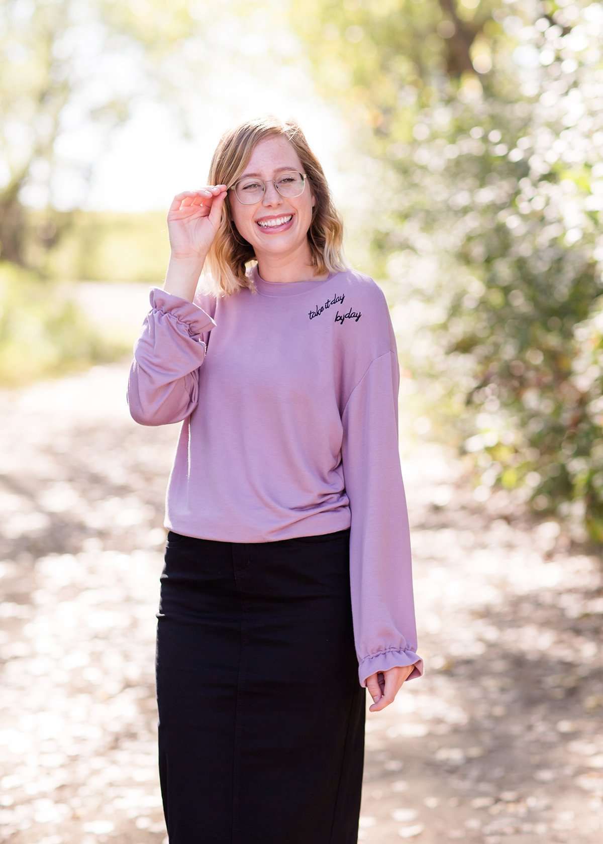 Lavender sweatshirt with ruffle at the end of the sleeves and embroidered up on the left shoulder with "Take it day by day."
