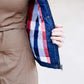 Woman wearing a denim quilted modest vest with a plaid and flannel lining.
