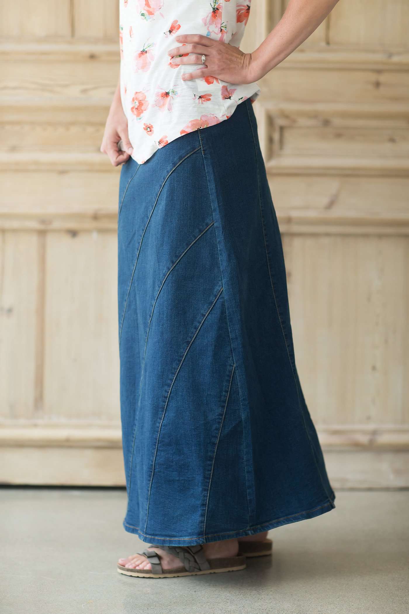 Women's denim a-line maxi skirt with diagonal detailing across the front and elastic waistband.