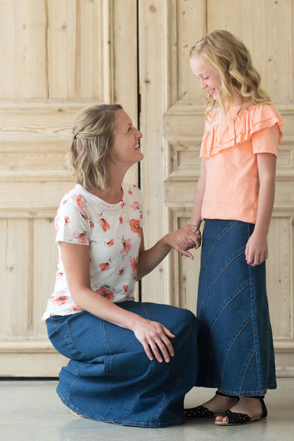 Women's denim a-line maxi skirt with diagonal detailing across the front and elastic waistband.