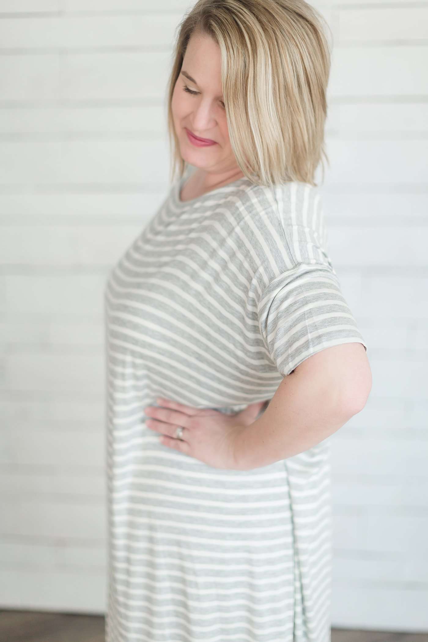 grey and white striped three quarter length sleeve midi dress with a modest crew neck top and side slit.