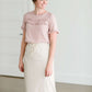 Woman wearing a modes blush double ruffle top with ruffles on the sleeves.