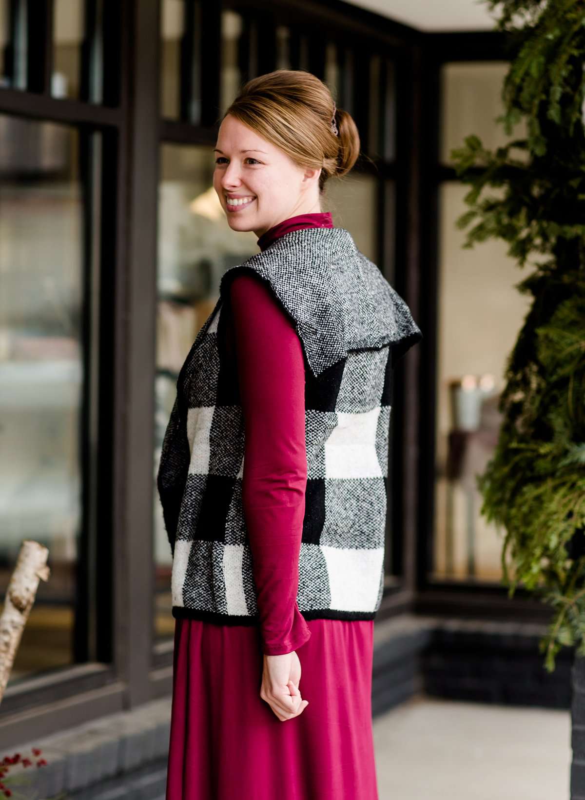 Woman wearing a sailor color, open front, black and white checker drape vest