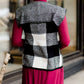 Woman wearing a sailor color, open front, black and white checker drape vest