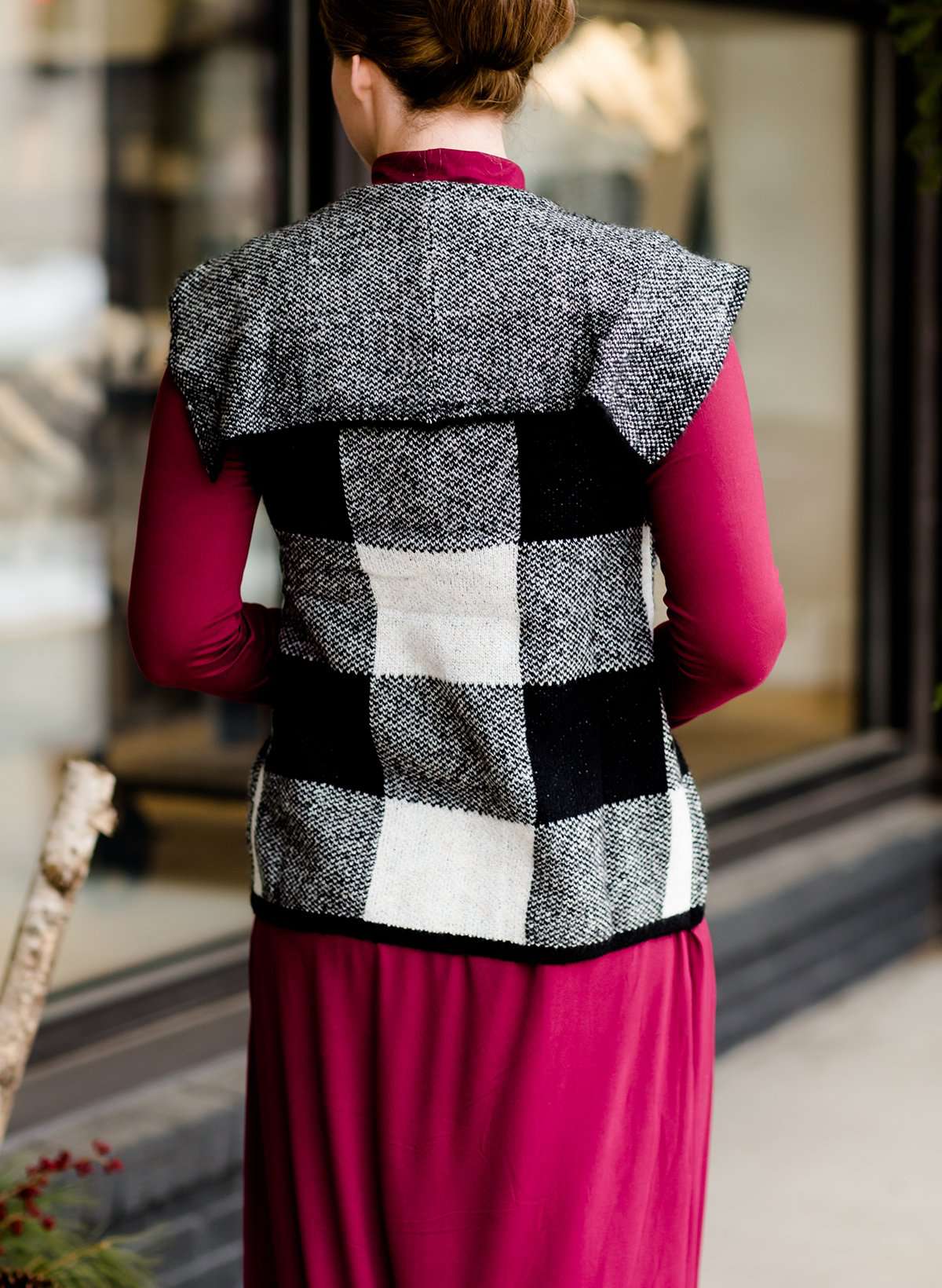 Woman wearing a sailor color, open front, black and white checker drape vest