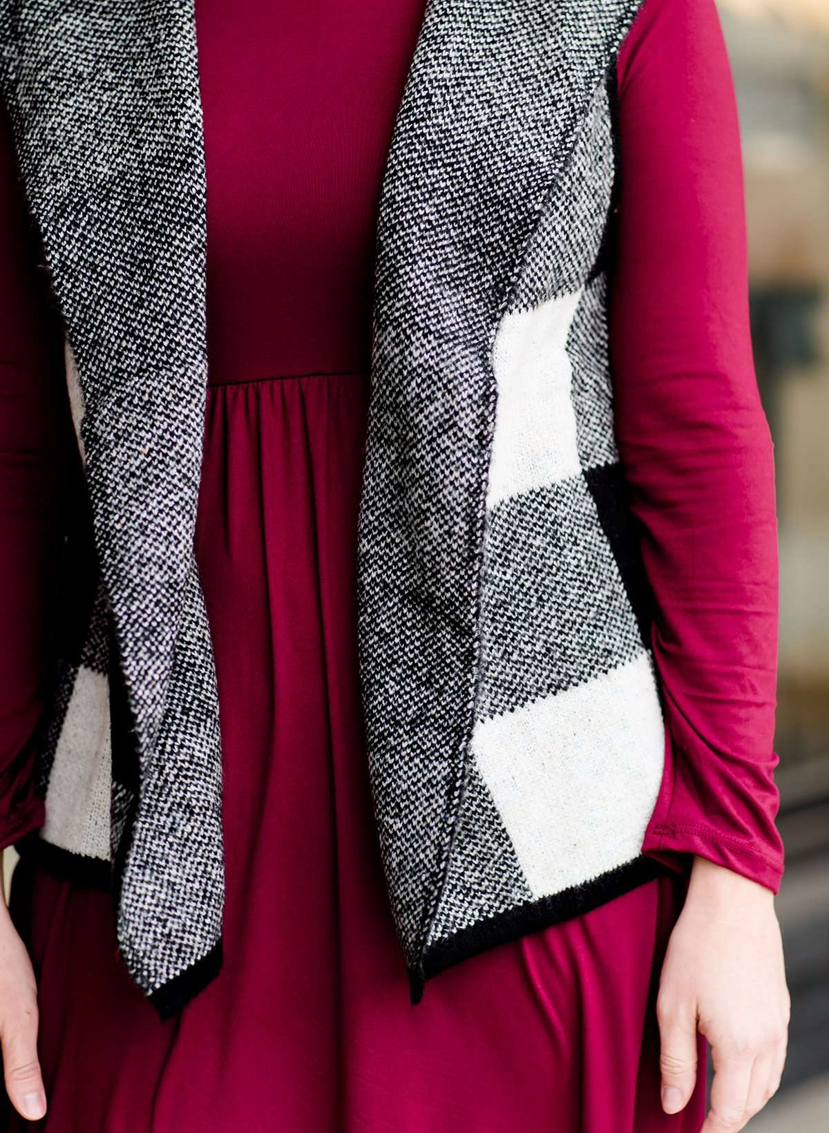 Woman wearing a sailor color, open front, black and white checker drape vest