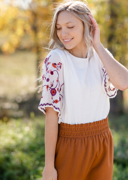 Fully lined you do not need to layer with this top with embroidered floral sleeves.