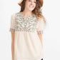 Woman wearing a blush embroidered bohemian style top