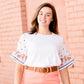 White top with multi color floral embroidered knit sleeves