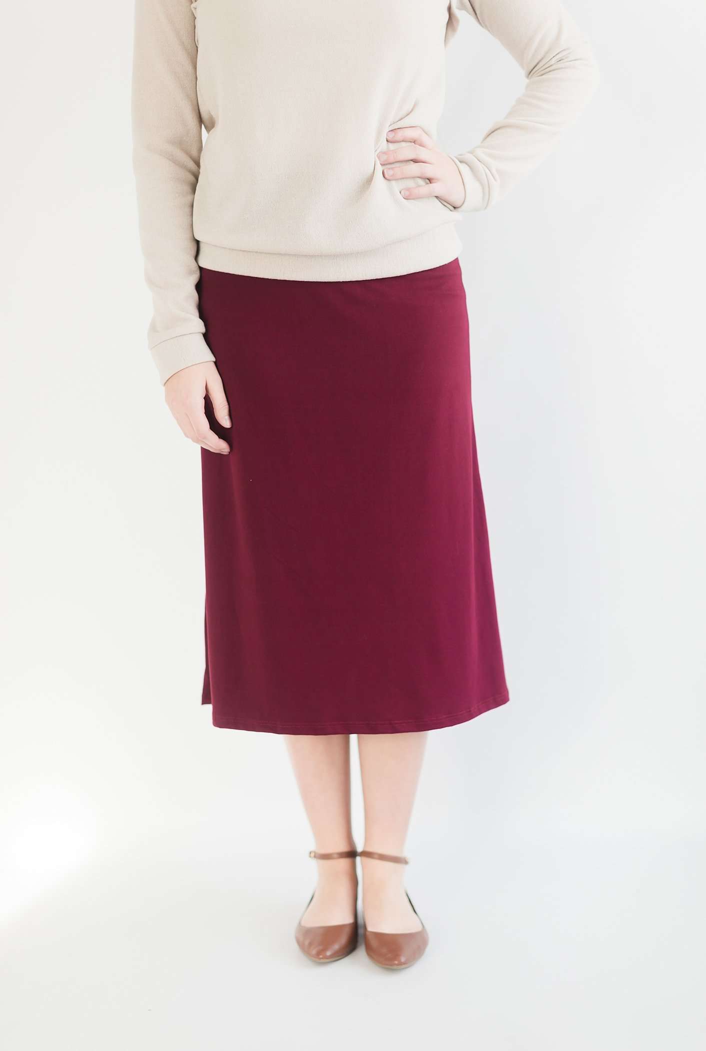 Woman wearing a midi skirt in black, olive, charcoal and Burgundy