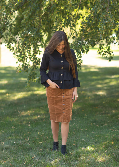 The Farrah Rust Corduroy Skirt is an Inherit Exclusive that is made with a fine corduroy texture that is extra stretchy. This midi skirt features button details down the front of the skirt with three functioning buttons at the top. There are functioning patch-style pockets on the front and a raw hem detail that finishes off the skirt. This midi skirt is super stretchy so you will feel comfortable and on-trend without compromising!