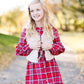 Young girl wearing a cream colored faux fur vest. It is a modest layering vest that also features beaded detail