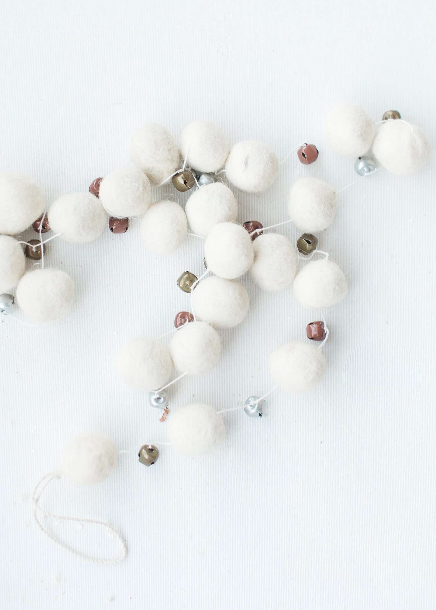 white, brown, olive felt garland balls on a string