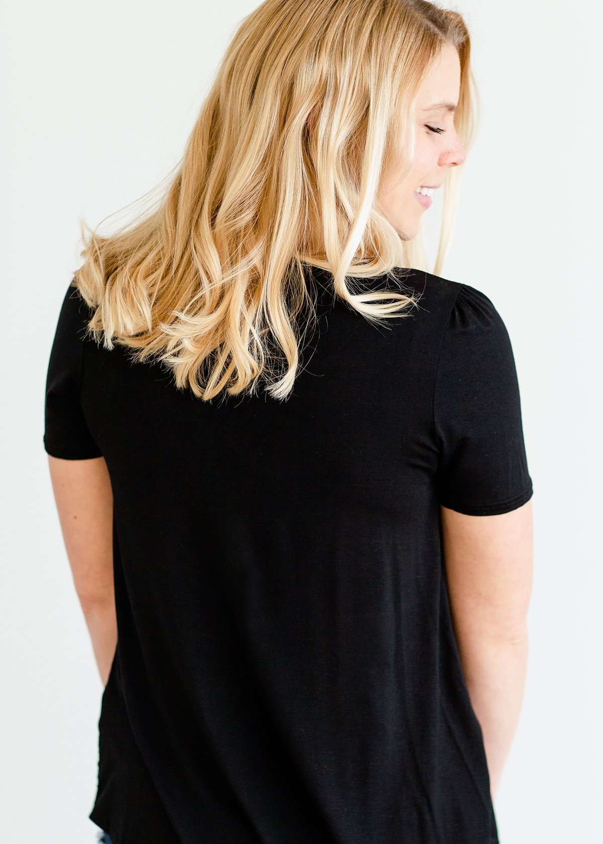 Woman wearing a modest black top with a denim jean skirt