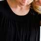 Woman wearing a modest black top with a denim jean skirt
