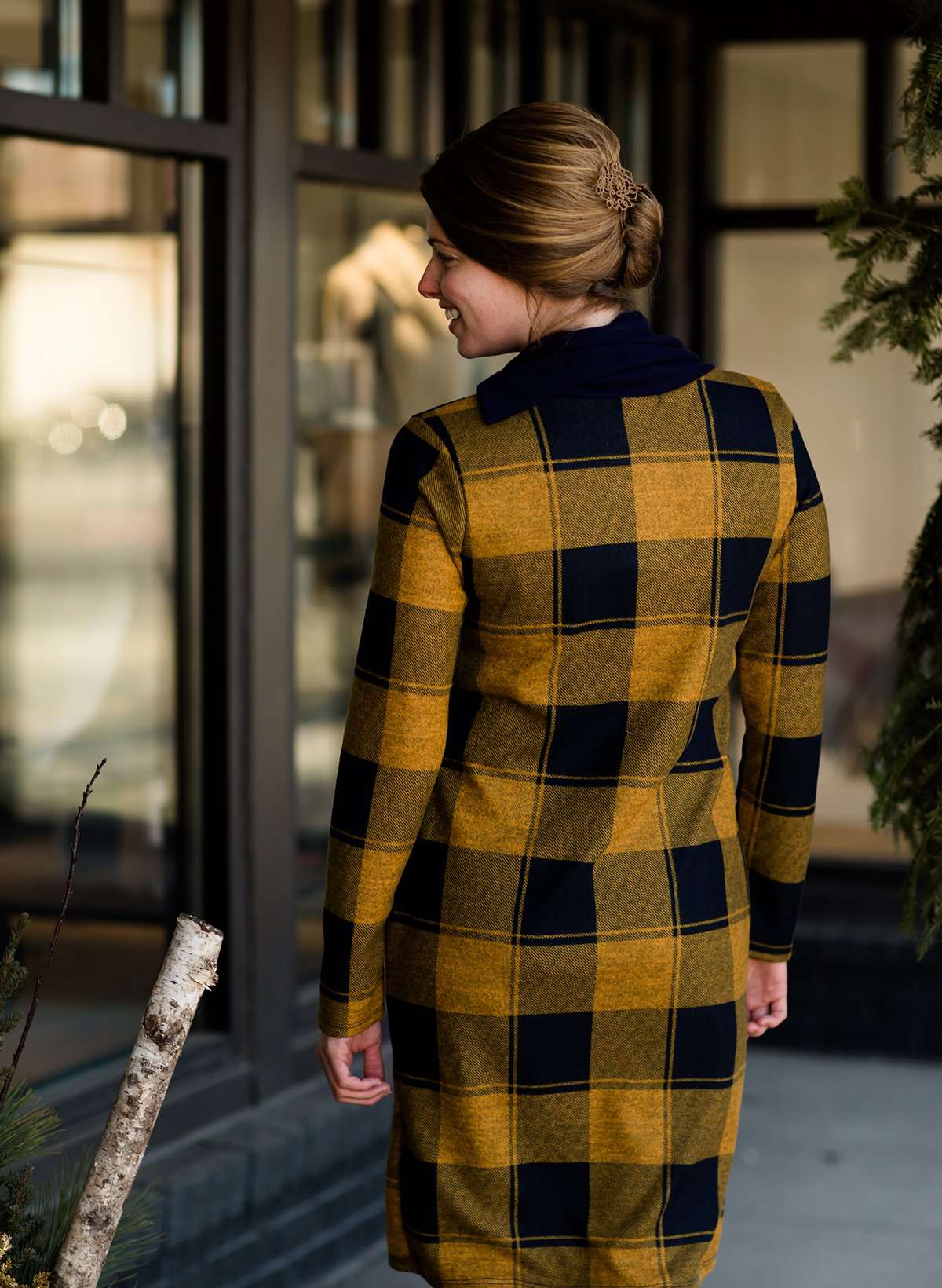 Woman wearing a Mustard and Navy buffalo check, flannel shift dress at Inherit Clothing Company.