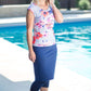 Woman by pool wearing a gray and floral modest swimsuit top